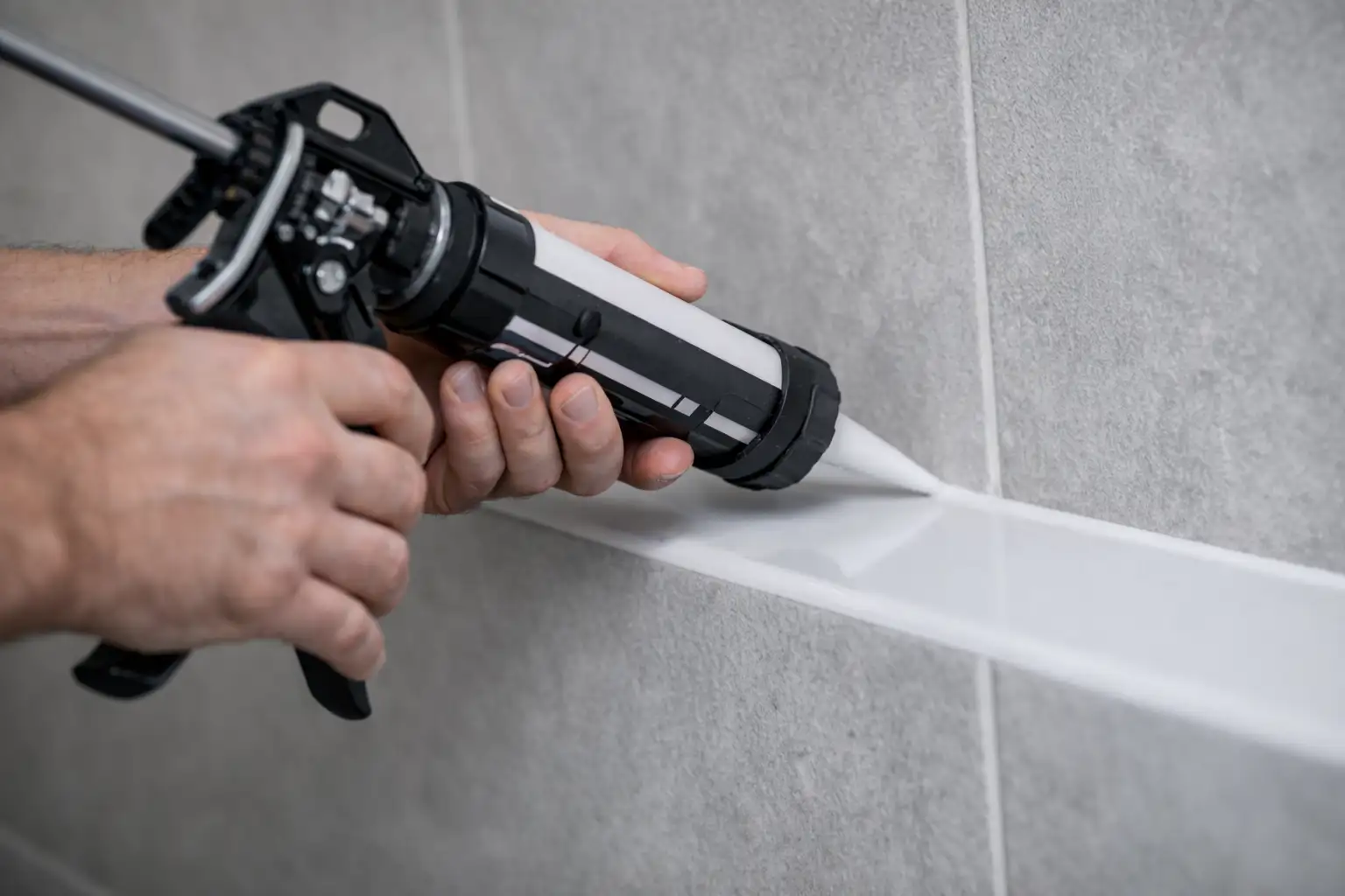 Håndværker påfører fugemasse i badeværelse